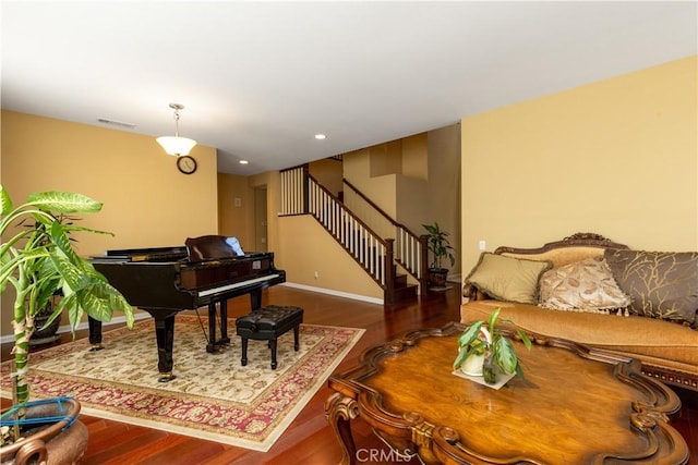 living room featuring recessed lighting, wood finished floors, visible vents, baseboards, and stairs