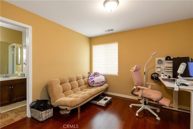 office with dark wood-style floors, baseboards, visible vents, and a sink