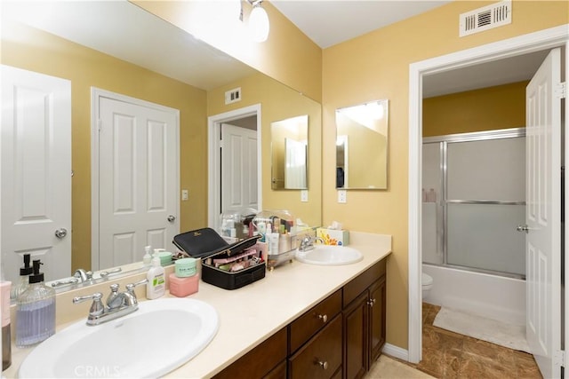 full bath featuring visible vents, a sink, and combined bath / shower with glass door