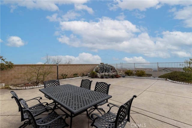 view of patio featuring outdoor dining space and fence