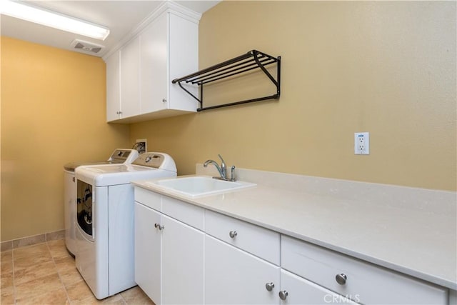 laundry area with cabinet space, a sink, visible vents, and washing machine and clothes dryer