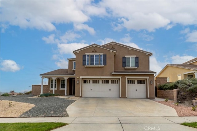 view of front of house with a garage, driveway, and stucco siding