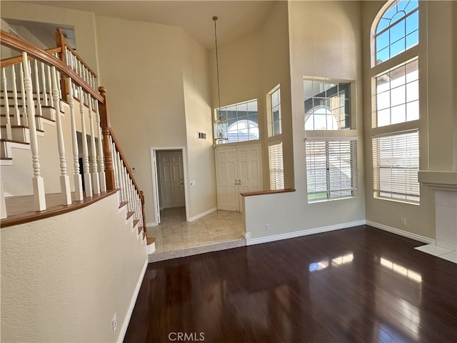 entryway with hardwood / wood-style floors and a high ceiling