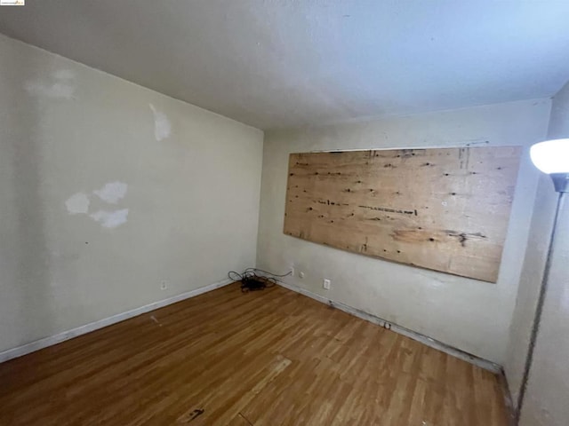 unfurnished room with wood-type flooring