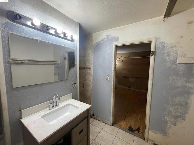 bathroom with hardwood / wood-style floors, vanity, and a textured ceiling