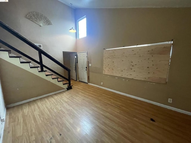 foyer with hardwood / wood-style flooring and high vaulted ceiling