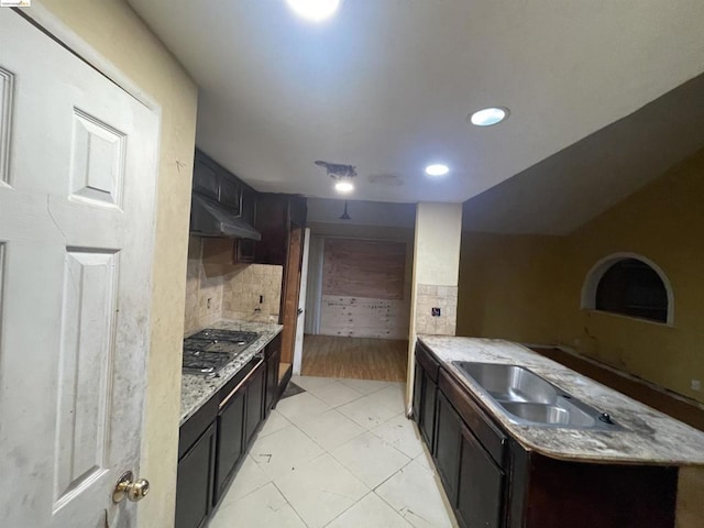 kitchen featuring tasteful backsplash, black gas stovetop, sink, and light wood-type flooring