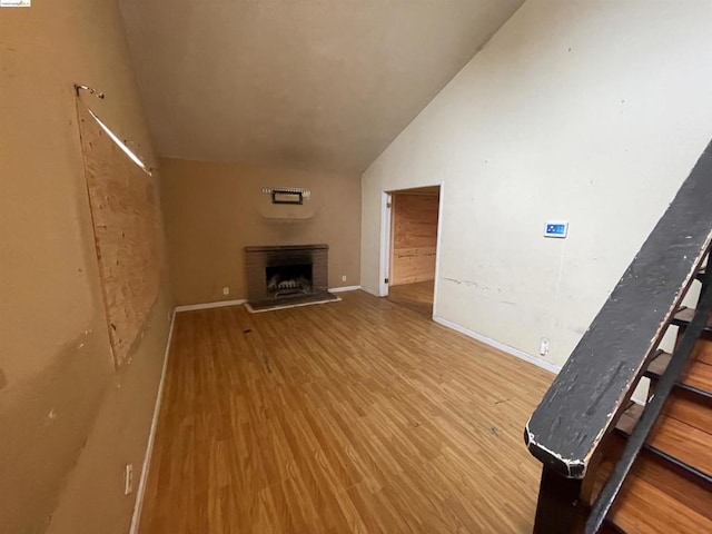 unfurnished living room with a fireplace, hardwood / wood-style floors, and vaulted ceiling