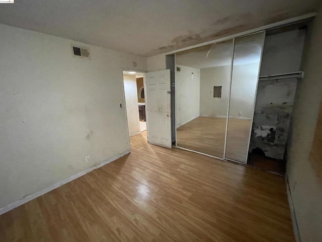 unfurnished bedroom with hardwood / wood-style floors and a closet