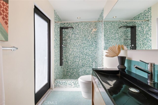 bathroom with tile patterned flooring, toilet, a shower with door, and vanity