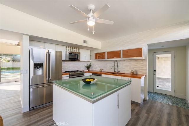 kitchen with a center island, sink, stainless steel appliances, and white cabinetry