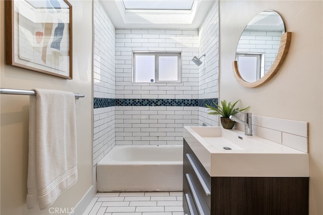 bathroom with tile patterned floors, vanity, and tiled shower / bath combo