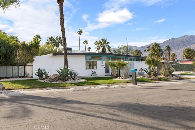 ranch-style house with a mountain view and a front lawn