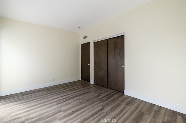 unfurnished bedroom featuring a closet and hardwood / wood-style flooring