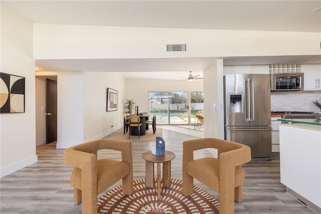 living room with light wood-type flooring and ceiling fan