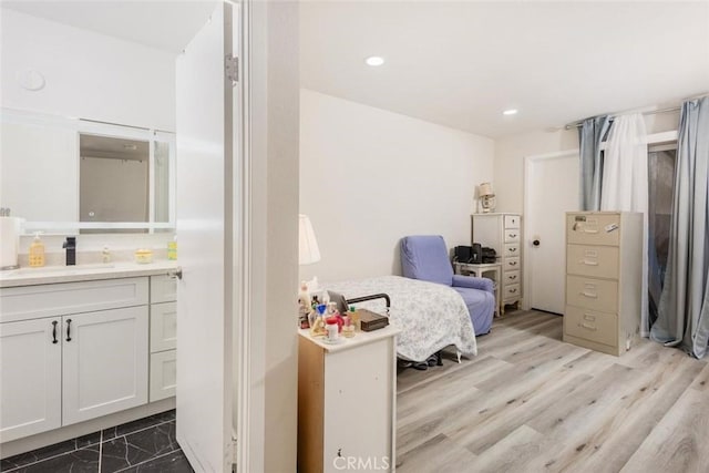 bedroom with light hardwood / wood-style floors and sink