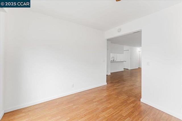 unfurnished room with sink and light hardwood / wood-style flooring