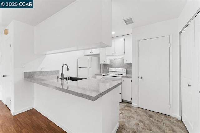 kitchen featuring sink, white appliances, backsplash, white cabinets, and kitchen peninsula