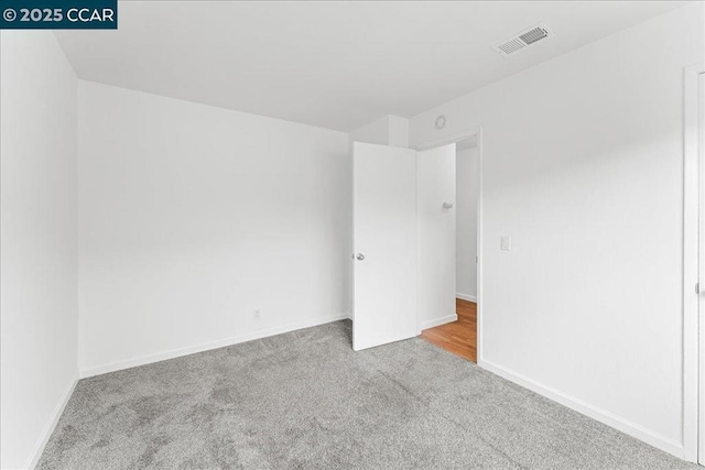 unfurnished room featuring light colored carpet