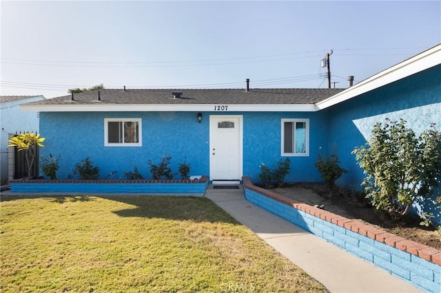 single story home featuring a front lawn