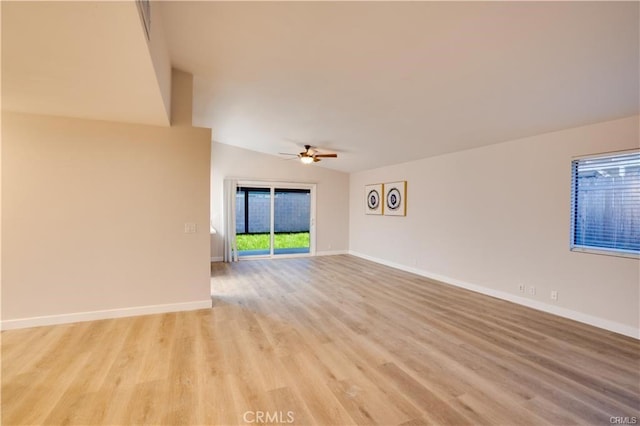 unfurnished room with ceiling fan, vaulted ceiling, and light wood-type flooring