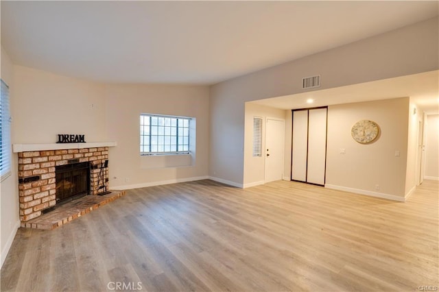 unfurnished living room featuring a fireplace and light hardwood / wood-style flooring