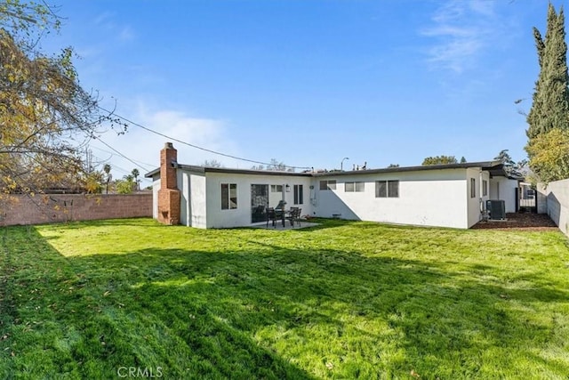 rear view of house featuring a lawn and cooling unit