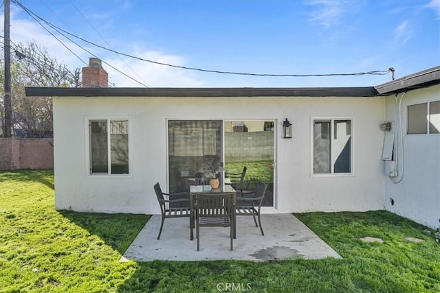 rear view of property featuring a lawn and a patio area