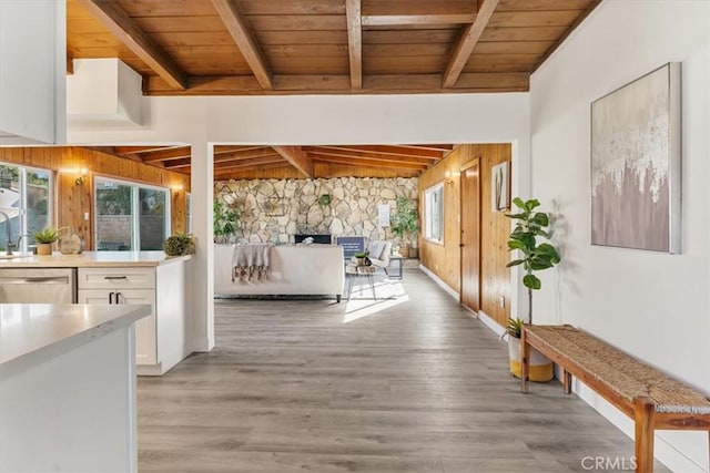 interior space featuring lofted ceiling with beams, light hardwood / wood-style floors, and wood ceiling