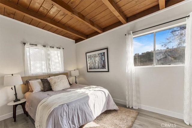 bedroom with beamed ceiling, wooden ceiling, and multiple windows