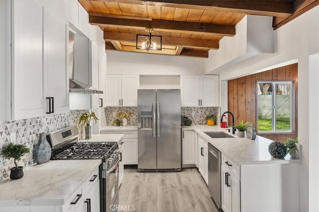 kitchen with sink, white cabinets, hanging light fixtures, and appliances with stainless steel finishes