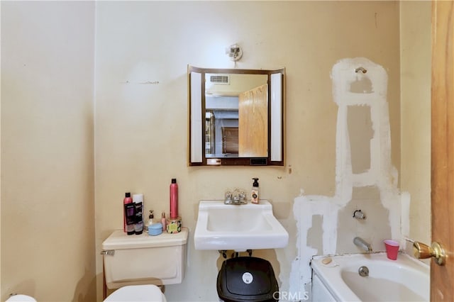 bathroom featuring a bathing tub, sink, and toilet