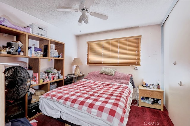 bedroom featuring ceiling fan, a textured ceiling, and dark colored carpet