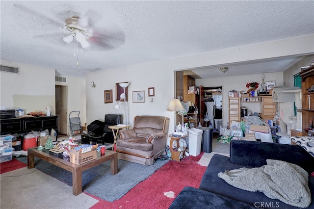 living room featuring carpet, a textured ceiling, and ceiling fan