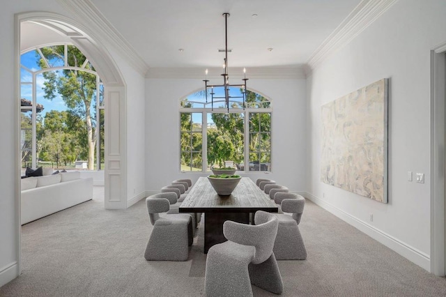 carpeted dining area with an inviting chandelier, a healthy amount of sunlight, and ornamental molding