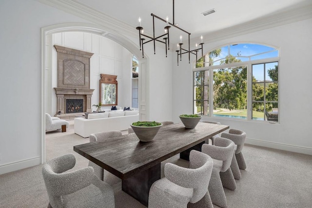 carpeted dining area featuring a chandelier and ornamental molding