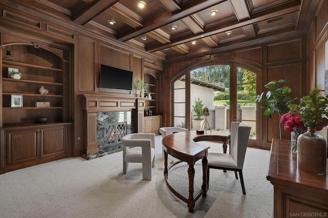 living area with beam ceiling, ornamental molding, wooden walls, and coffered ceiling