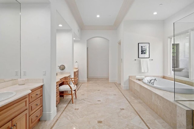 bathroom with a relaxing tiled tub and vanity