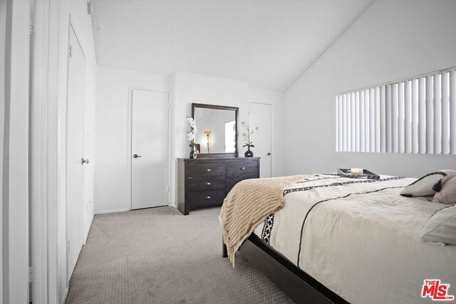 carpeted bedroom featuring lofted ceiling