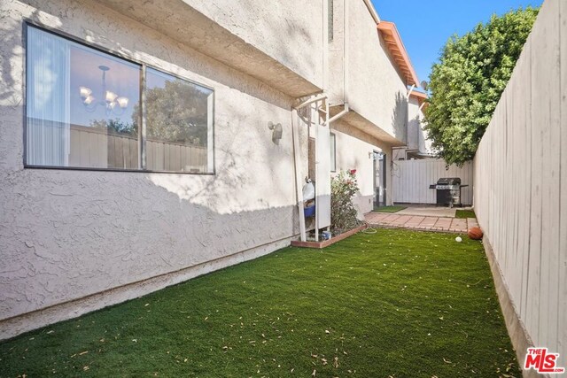 view of side of property with a yard and a patio