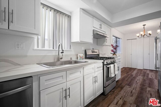 kitchen featuring pendant lighting, stainless steel appliances, sink, and white cabinets