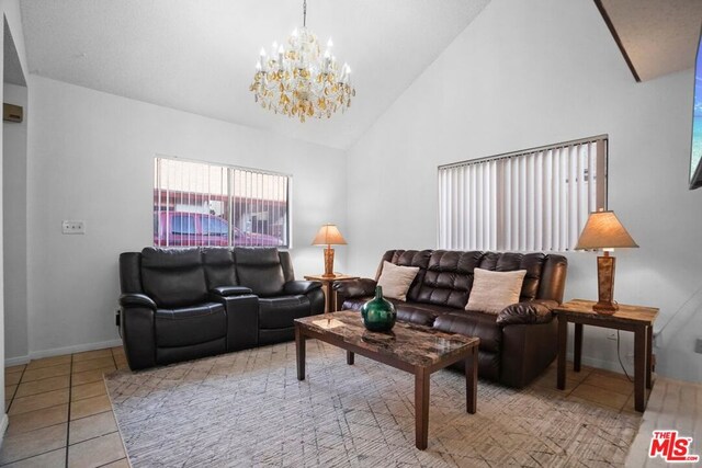 living room with an inviting chandelier, high vaulted ceiling, and light tile patterned floors