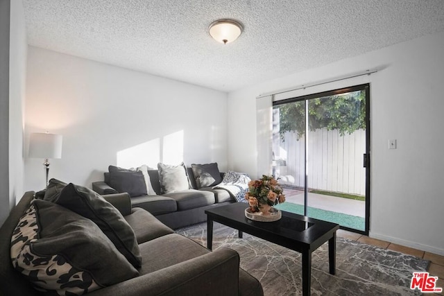 tiled living room featuring a textured ceiling