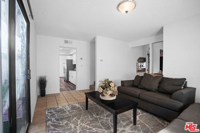 living room with tile patterned floors and a textured ceiling