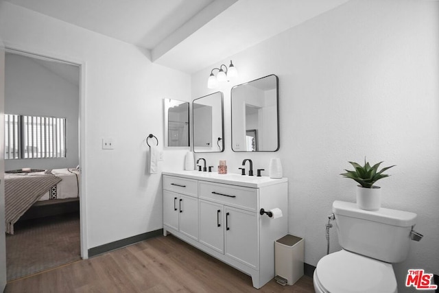 bathroom featuring wood-type flooring, vanity, and toilet