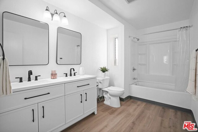 full bathroom with toilet, wood-type flooring, shower / bathtub combination with curtain, and vanity