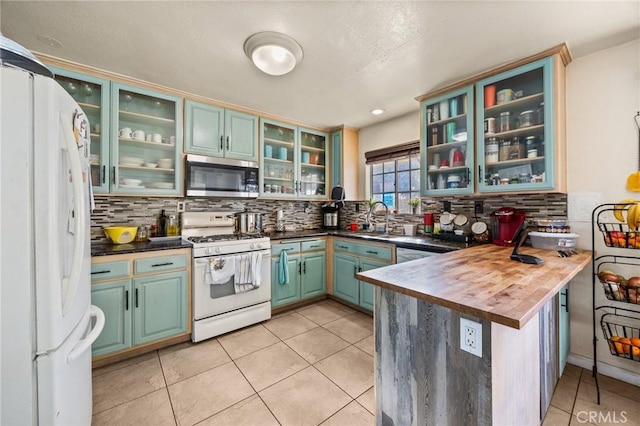 kitchen featuring butcher block countertops, sink, white appliances, and backsplash