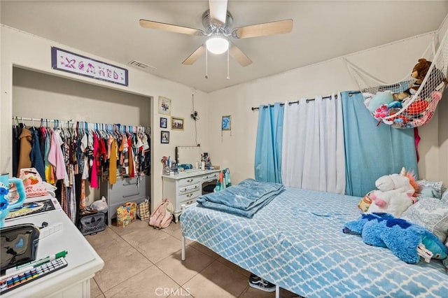 bedroom with tile patterned flooring, a closet, and ceiling fan