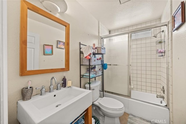 full bathroom with vanity, enclosed tub / shower combo, a textured ceiling, and toilet