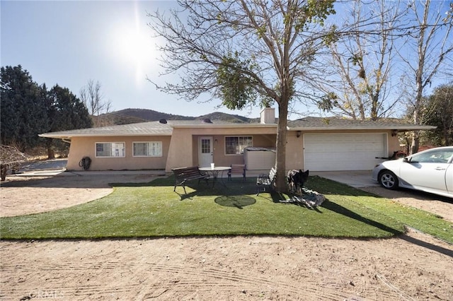 ranch-style home featuring a front yard and a garage